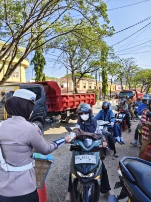Wujud Polri Humanis, Polwan Satlantas Polres Bone Bagikan Air Mineral ke Pengendara yang Antre BBM